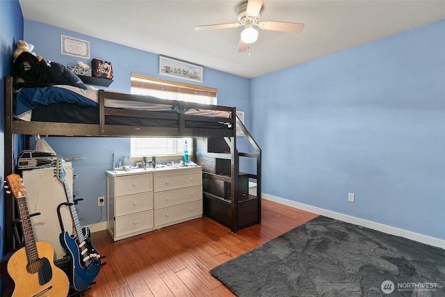 bedroom featuring wood finished floors, a ceiling fan, and baseboards