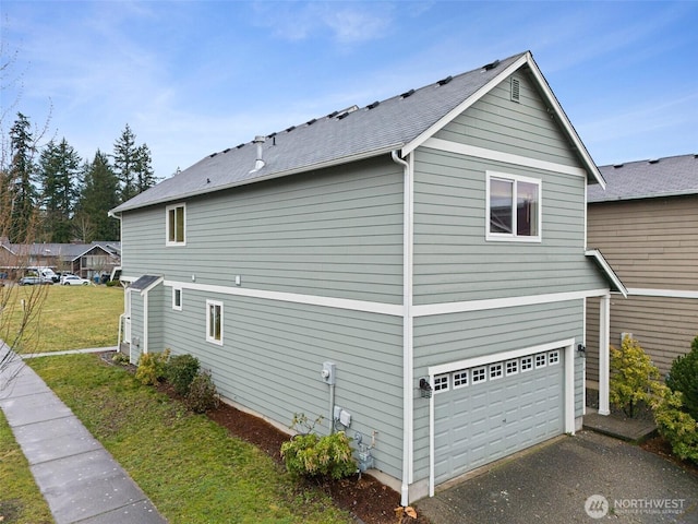 view of side of home featuring a garage and a yard