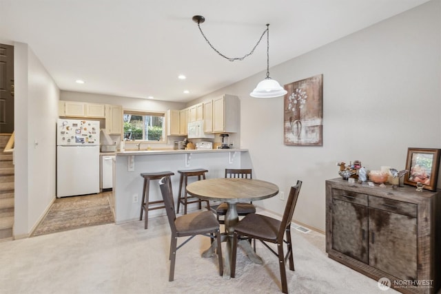 dining room featuring recessed lighting, stairs, baseboards, and light colored carpet