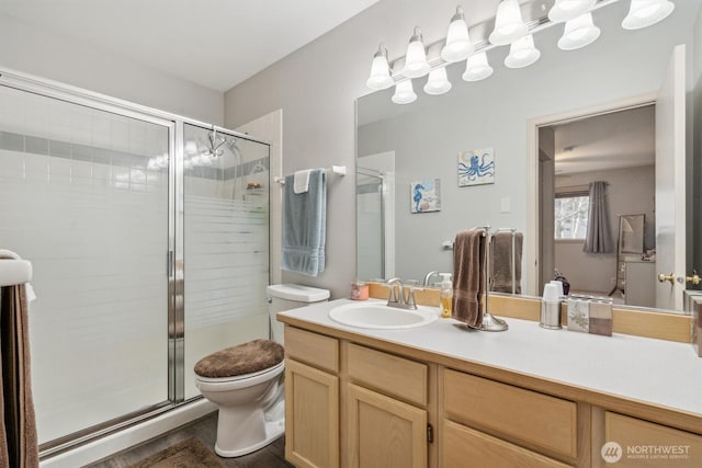 bathroom with a stall shower, vanity, and toilet