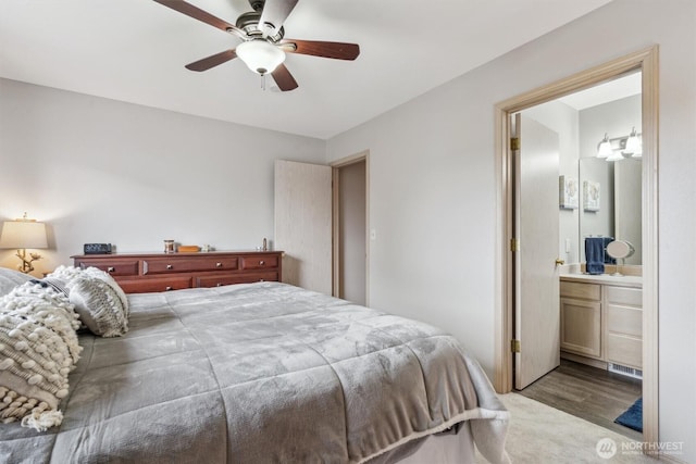 bedroom featuring a ceiling fan, wood finished floors, and ensuite bathroom