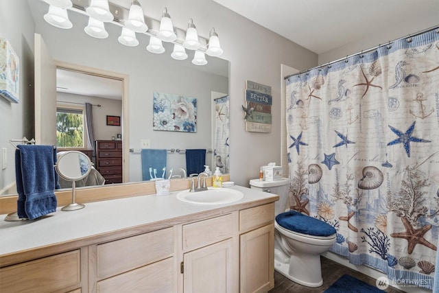 full bathroom featuring wood finished floors, vanity, and toilet