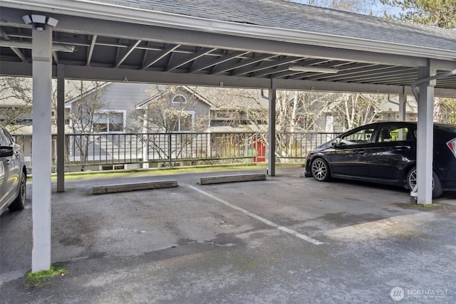 covered parking lot featuring fence