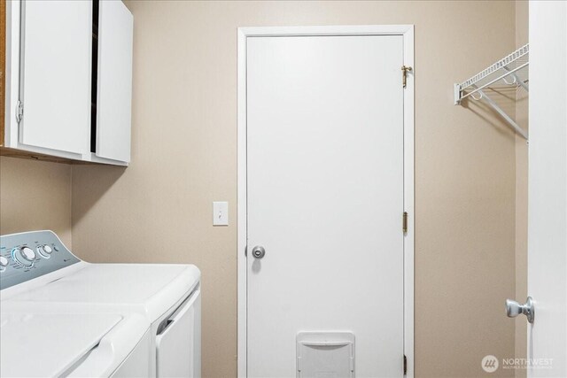 washroom featuring cabinet space and separate washer and dryer