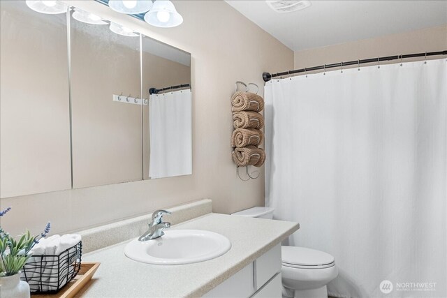 bathroom with visible vents, toilet, and vanity