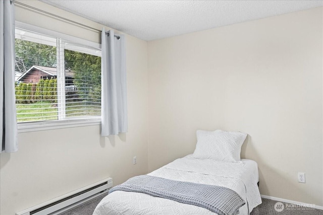 carpeted bedroom featuring a baseboard heating unit, baseboards, and a textured ceiling