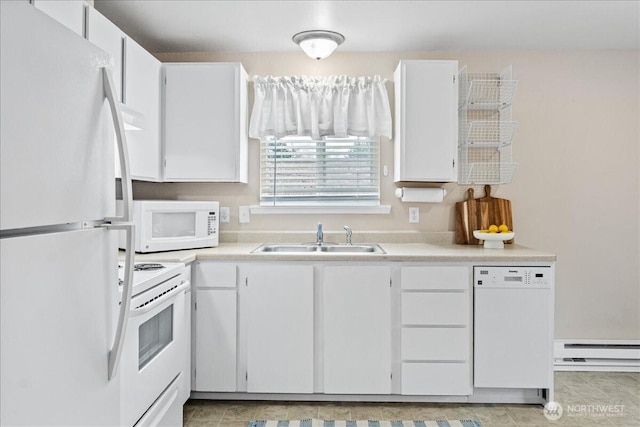 kitchen featuring white appliances, light countertops, a baseboard heating unit, and a sink