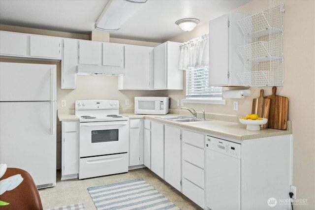 kitchen with a sink, under cabinet range hood, white cabinetry, white appliances, and light countertops