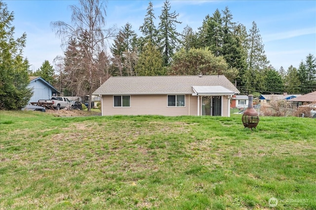 rear view of house featuring a yard