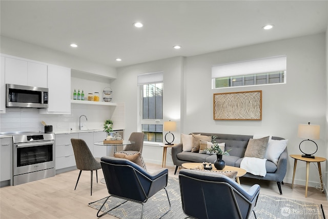 living room featuring light wood-style floors, baseboards, and recessed lighting