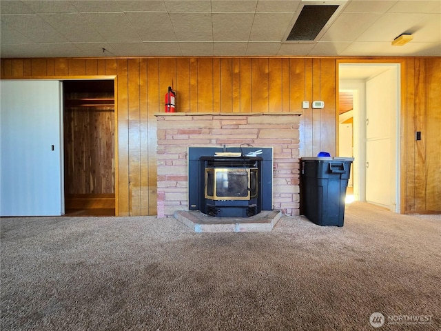 room details featuring carpet, a fire extinguisher, visible vents, a wood stove, and wooden walls