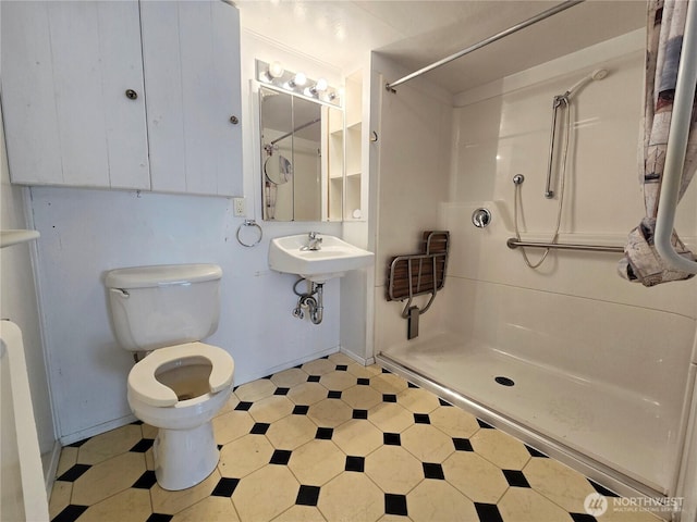 bathroom featuring a sink, walk in shower, toilet, and tile patterned floors