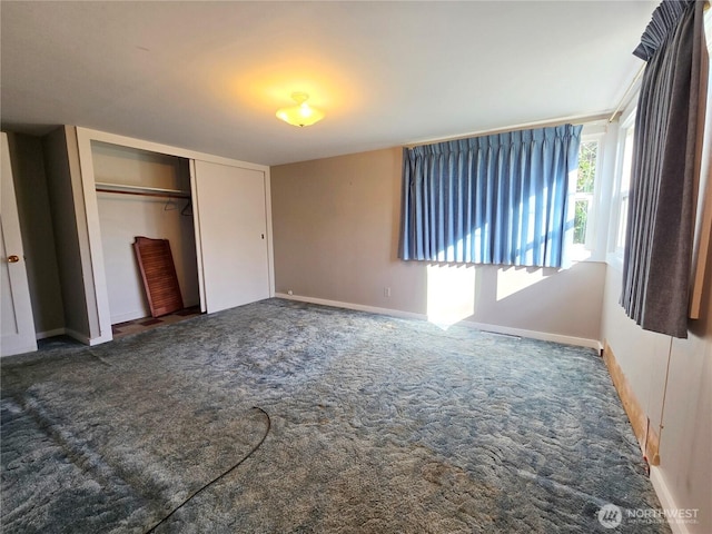 unfurnished bedroom featuring baseboards, a closet, and carpet flooring