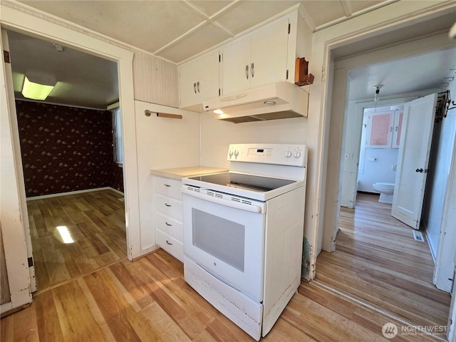 kitchen featuring light wood finished floors, white range with electric cooktop, white cabinets, under cabinet range hood, and wallpapered walls