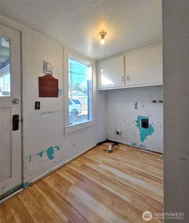 clothes washing area with wood finished floors and cabinet space