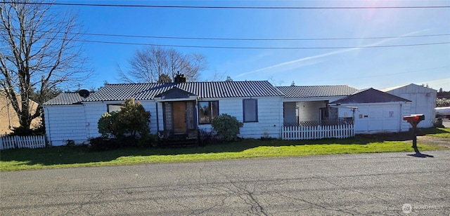 ranch-style home featuring a tile roof, fence, a chimney, and a front lawn