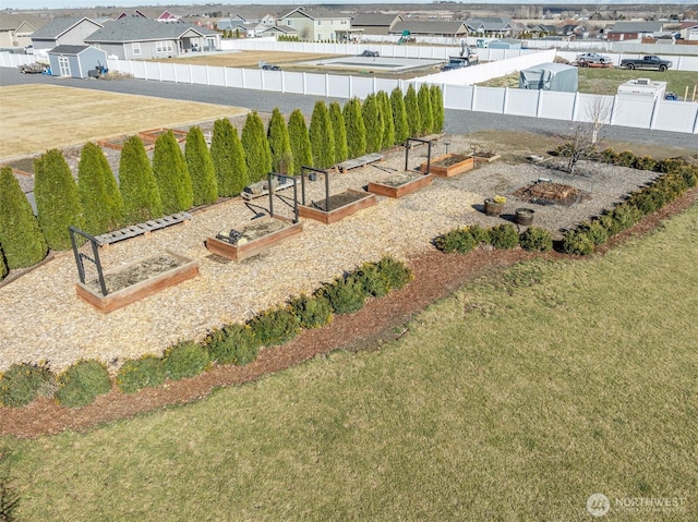 view of yard featuring a fenced backyard, a residential view, and a vegetable garden