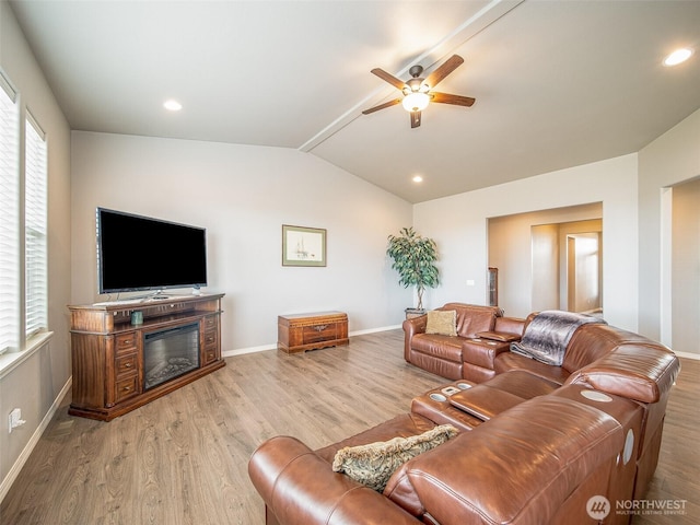 living room featuring lofted ceiling, baseboards, and wood finished floors