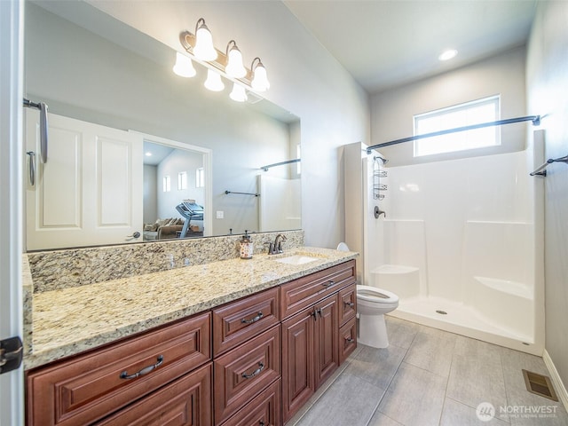 bathroom with a shower, visible vents, vanity, and toilet