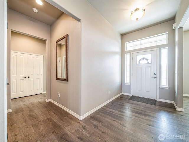 entrance foyer with dark wood finished floors and baseboards