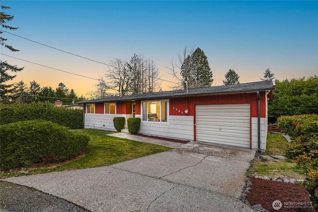 view of front of home featuring driveway, an attached garage, and a front yard