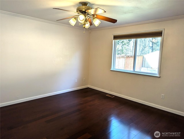 unfurnished room featuring ornamental molding, dark wood finished floors, visible vents, and baseboards