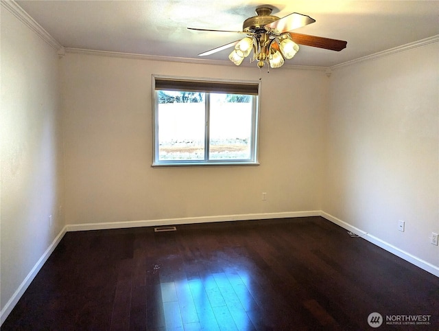 spare room with dark wood-style floors, visible vents, ornamental molding, ceiling fan, and baseboards