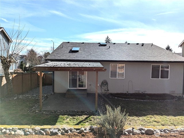 back of property featuring crawl space, a shingled roof, fence, and a patio