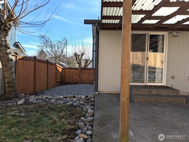 view of side of property with a fenced backyard and metal roof