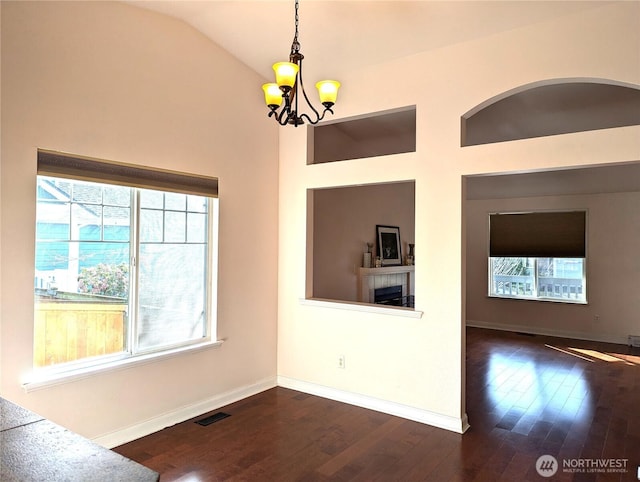 interior space featuring a chandelier, dark wood-type flooring, visible vents, and baseboards