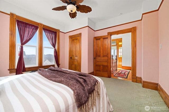 carpeted bedroom with baseboards and a ceiling fan