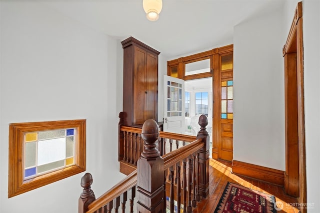 hallway featuring dark wood-style flooring and an upstairs landing