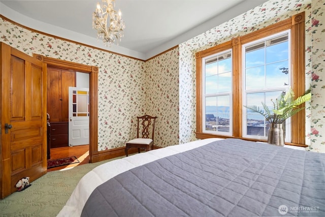 bedroom featuring wallpapered walls and an inviting chandelier