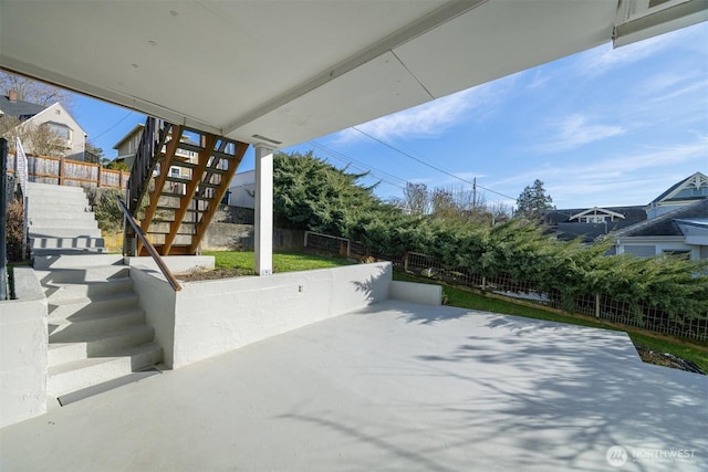 view of patio featuring stairway and fence