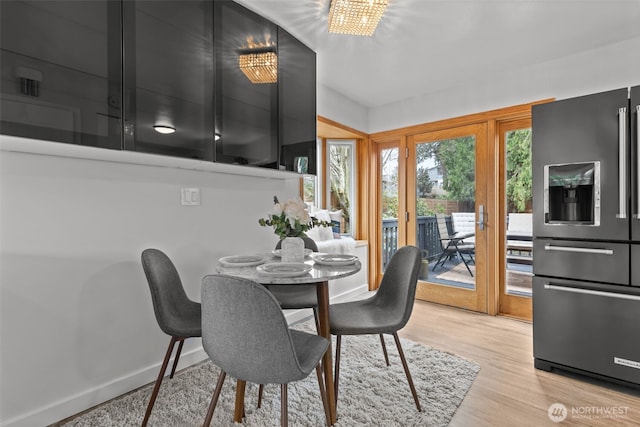 dining space with a chandelier, baseboards, and wood finished floors