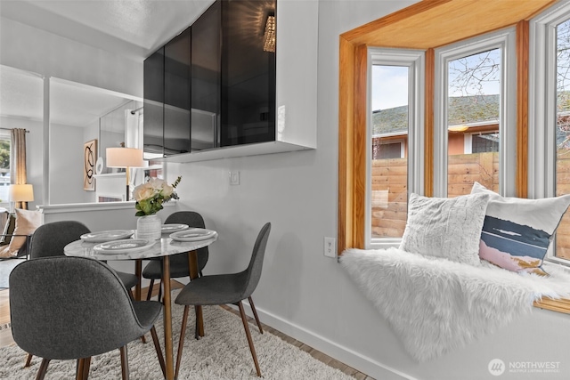 dining space with baseboards and wood finished floors