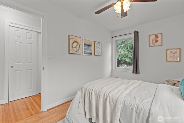 bedroom featuring light wood-type flooring, baseboards, and a ceiling fan