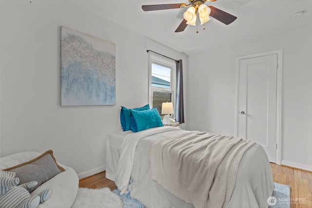 bedroom featuring ceiling fan, baseboards, and wood finished floors