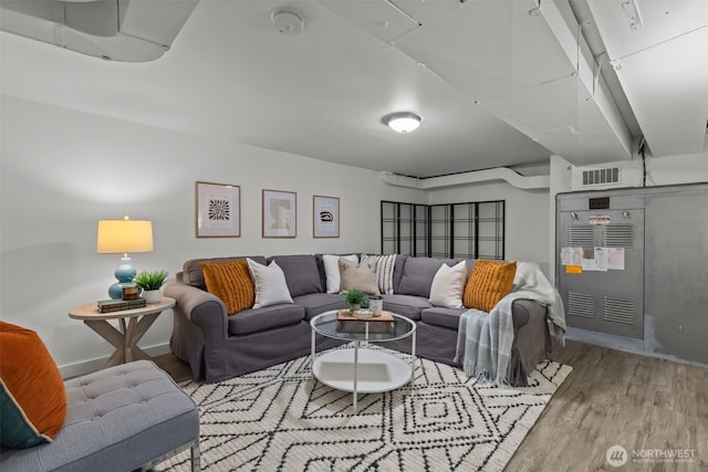 living area featuring visible vents, baseboards, and wood finished floors