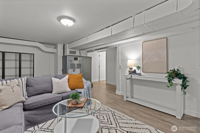 living room featuring baseboards, visible vents, and light wood-style floors