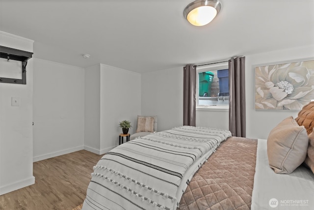 bedroom with baseboards and wood finished floors