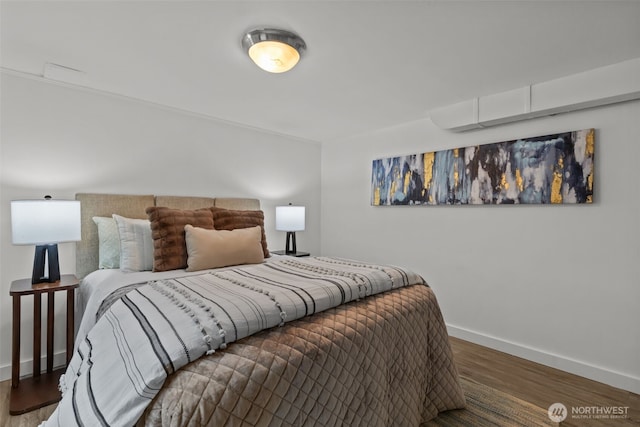 bedroom with baseboards and wood finished floors