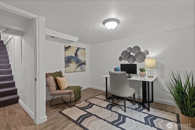 office featuring baseboards, visible vents, and wood finished floors