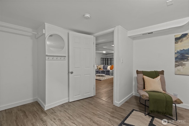 living area with baseboards, visible vents, and wood finished floors