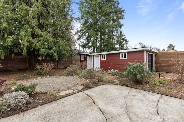 back of house featuring an outbuilding, a patio area, and fence