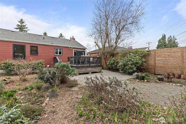 view of yard featuring fence, a wooden deck, and a patio