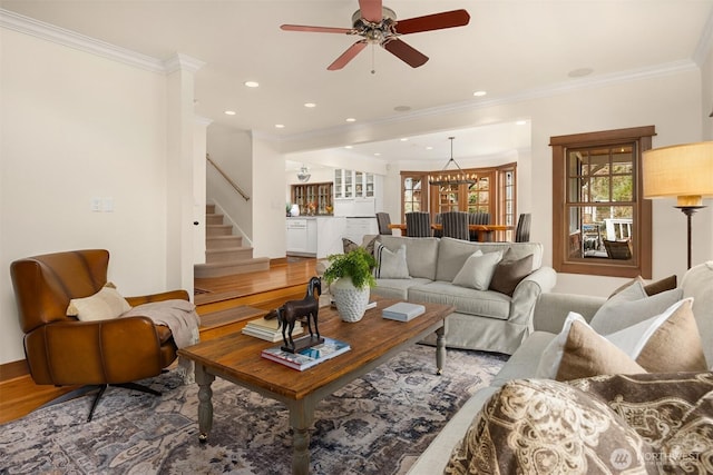 living room featuring ornamental molding, recessed lighting, light wood-style flooring, and stairs