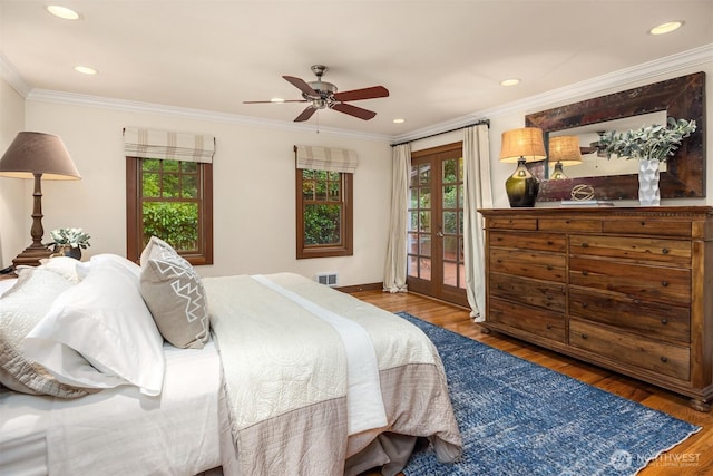 bedroom with wood finished floors, visible vents, access to outside, french doors, and ornamental molding