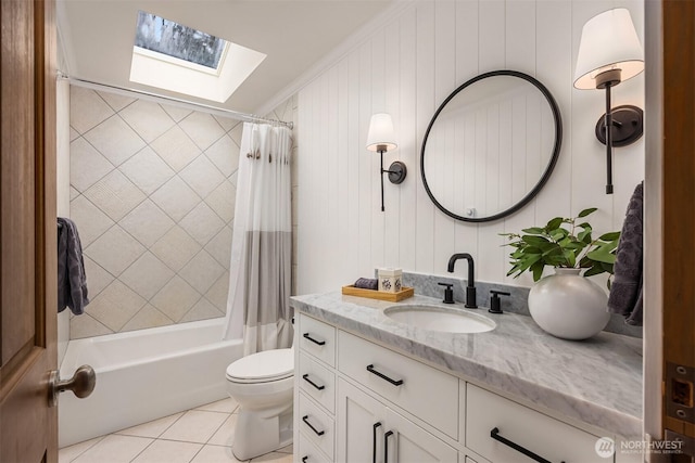 full bathroom with a skylight, shower / bath combo, toilet, tile patterned floors, and vanity