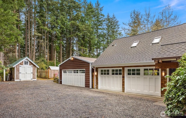 detached garage featuring fence